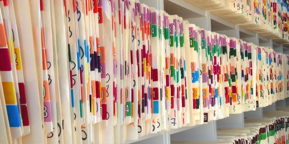 Rows of color-coded file folders in a records office — the kind of documents accessed through a California public records request.
